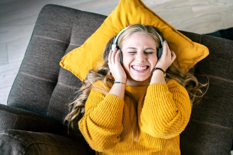 Kvinde lytter til musik i sofa