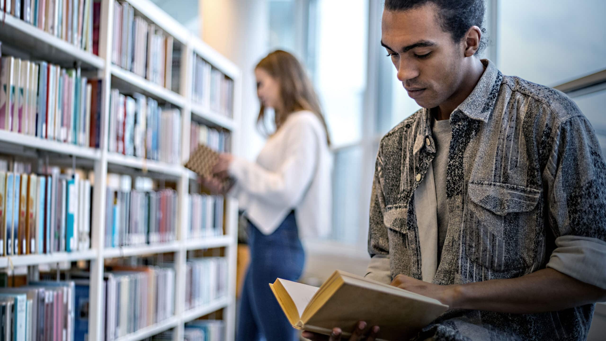 Person læser bog på bibliotek