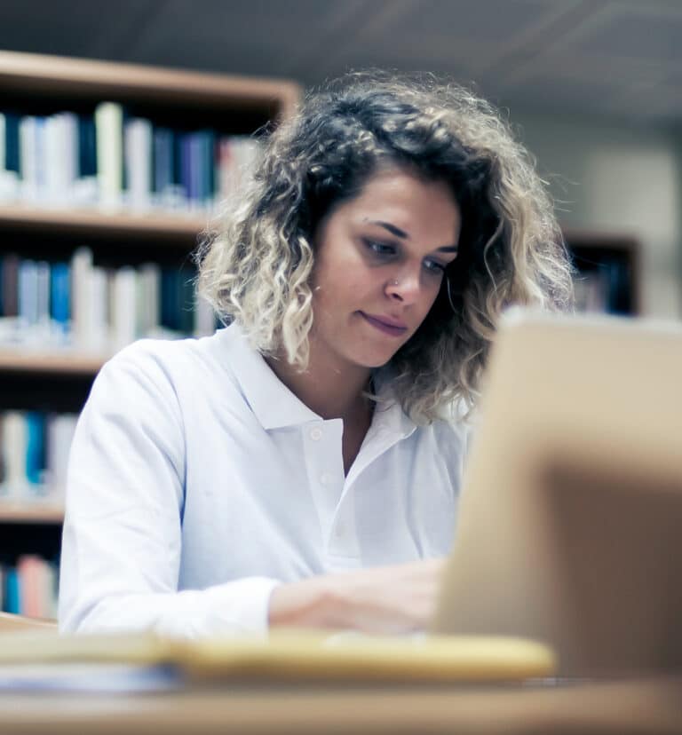 Person med computer på bibliotek